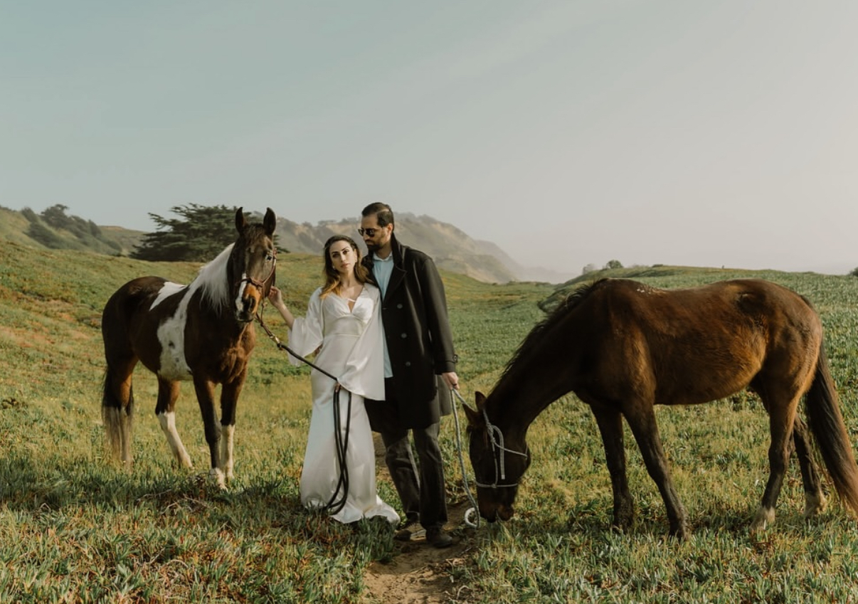 A couple with two horses on the coastal bluff